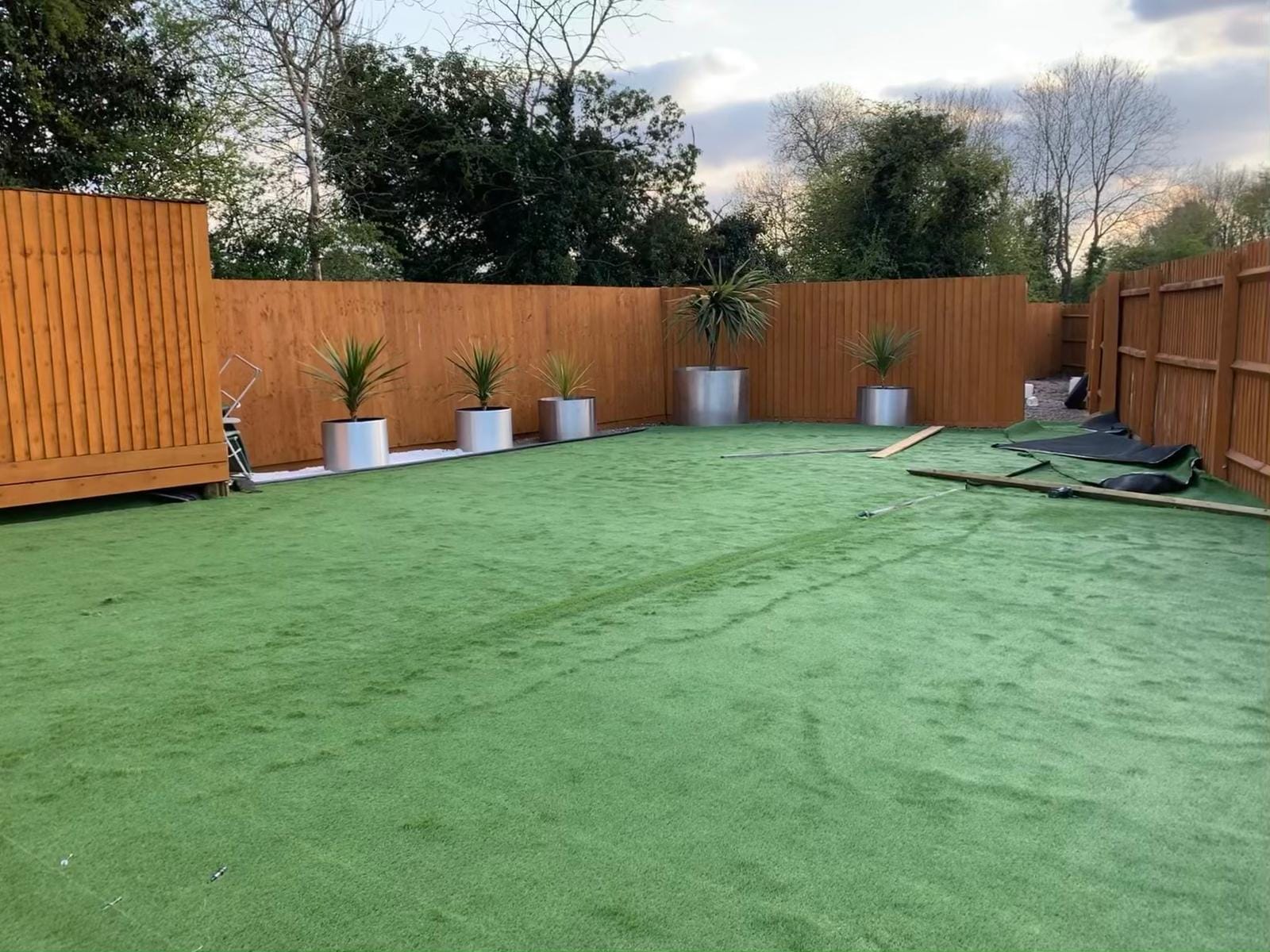 Newly installed artificial grass lawn surrounded by timber fencing
